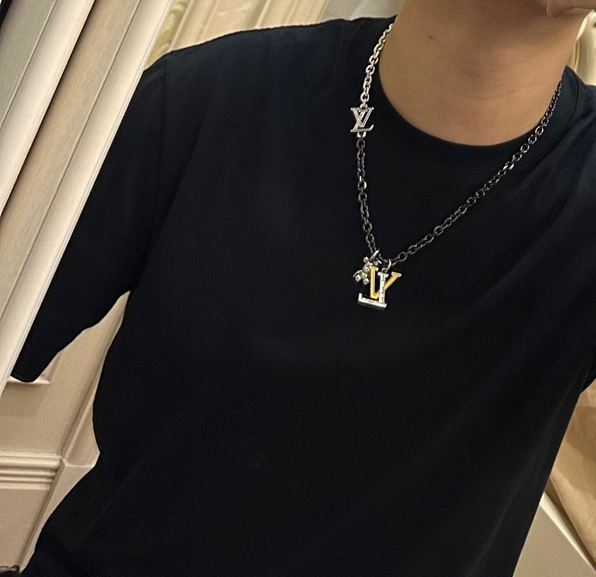 Louis Vuitton necklace on model, silver-tone chain with LV charm pendant