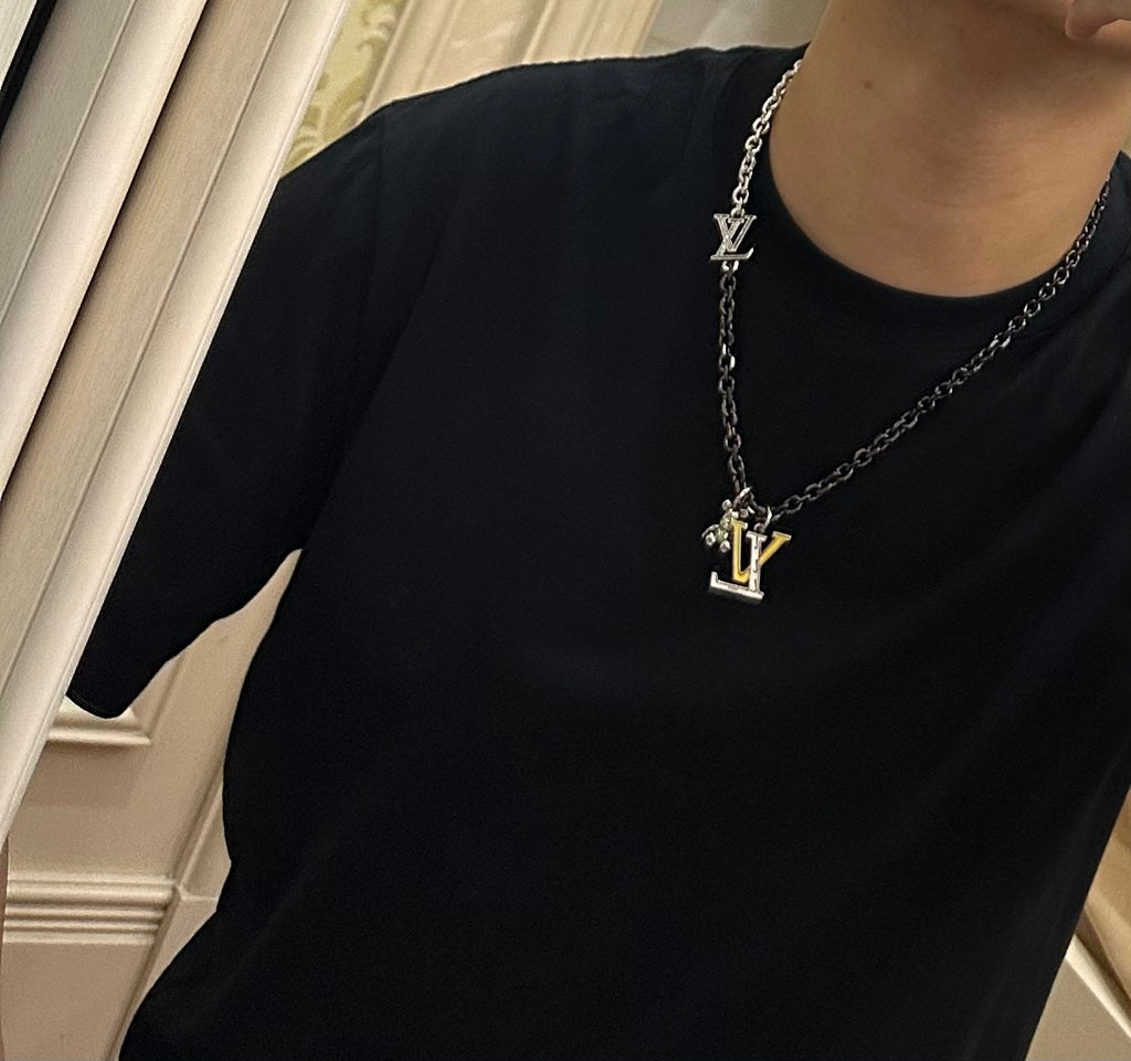 Louis Vuitton necklace on model, silver-tone chain with LV charm pendant