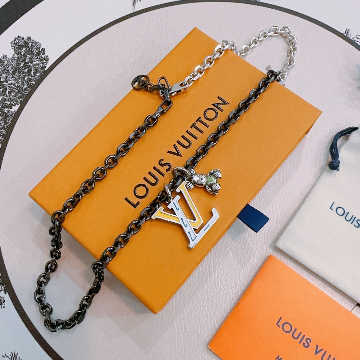Louis Vuitton necklace, black-and-silver chain with LV charm pendant on box