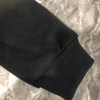 Dior long jacket sleeve cuff close-up with ribbed knit cuff on dark fabric