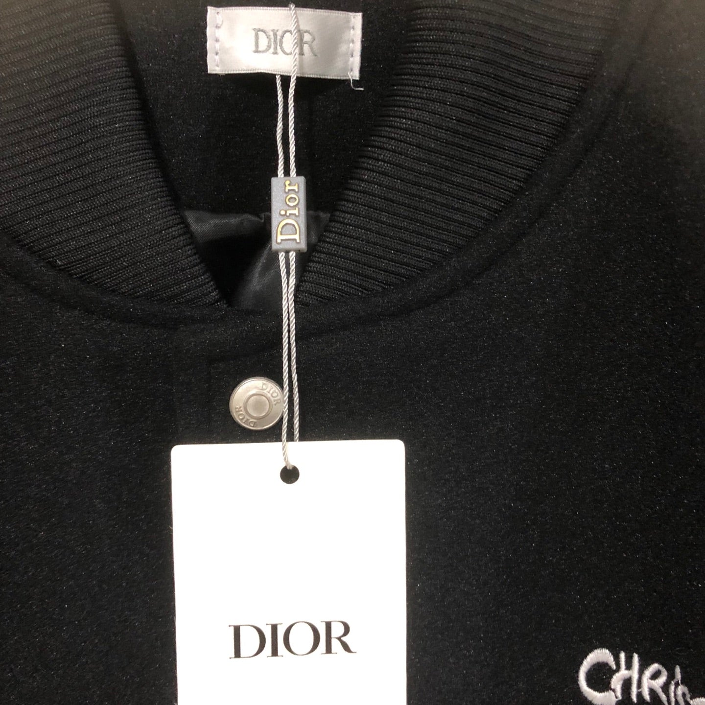Dior long jacket collar close-up with snap placket and brand logo label