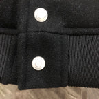 Dior long jacket front close-up showing two silver snap buttons on dark fabric