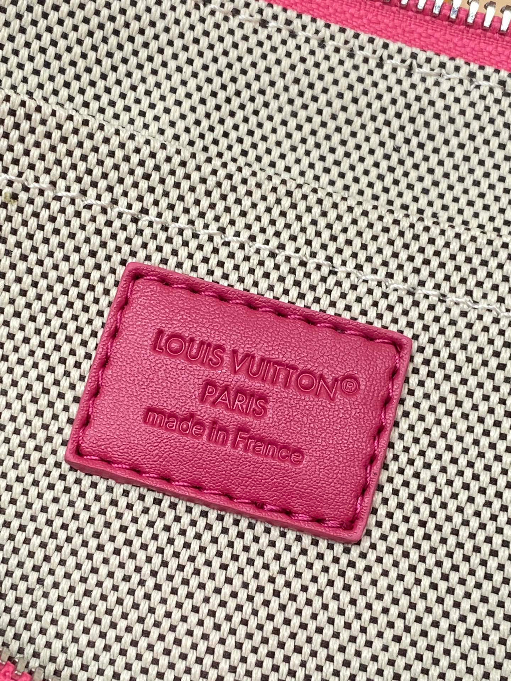 Louis Vuitton monogram clutch bag pink leather label reading “Made in France”