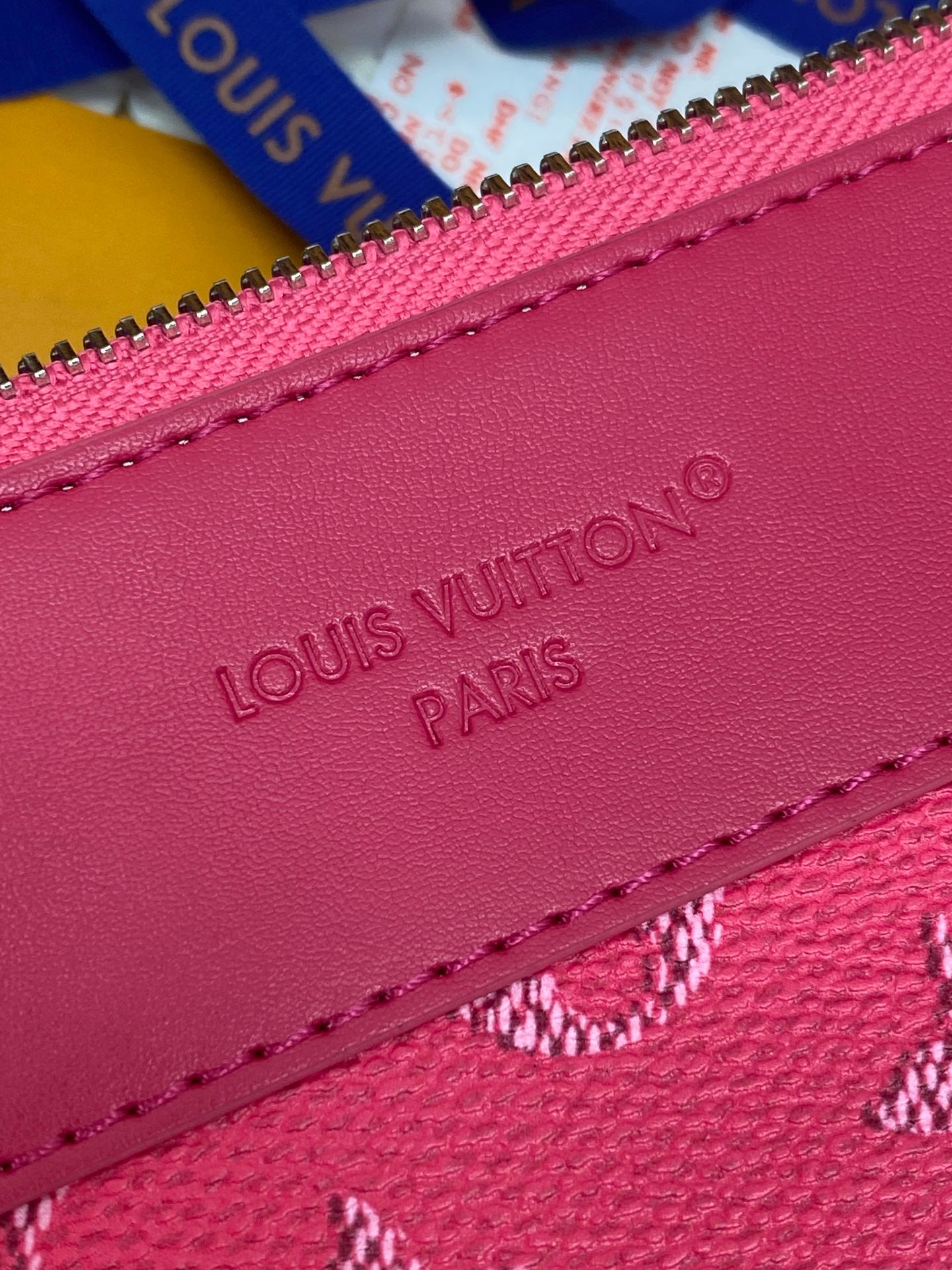Pink leather side of Louis Vuitton clutch bag with embossed 'Louis Vuitton Paris'