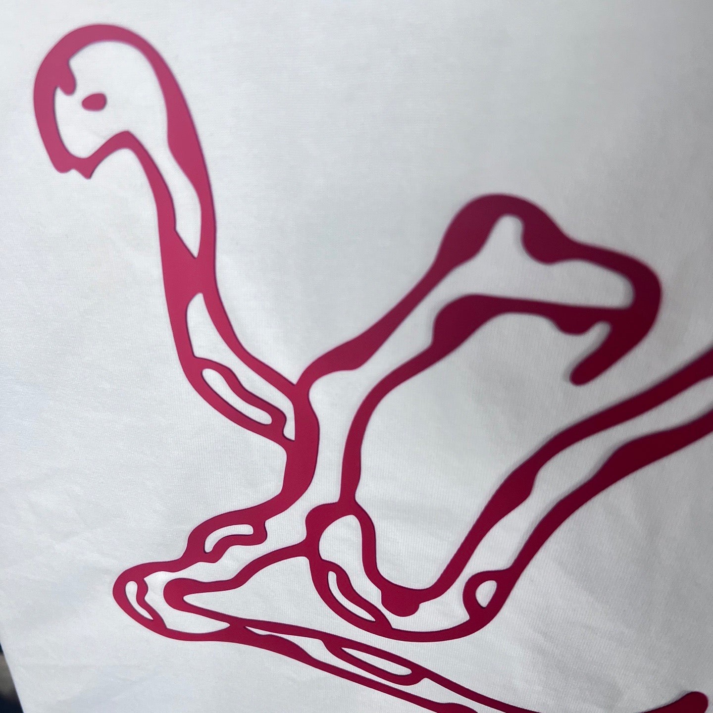 Maroon logo line art graphic on white sweatshirt fabric