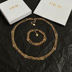 Gold-tone chain necklace with round charm and small pendant