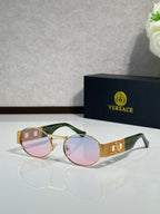 Round sunglasses with multicolor frames (gold and green) and pink tinted lenses.