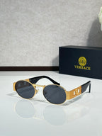 Round sunglasses with gold frames and dark tinted lenses; black temple accents.
