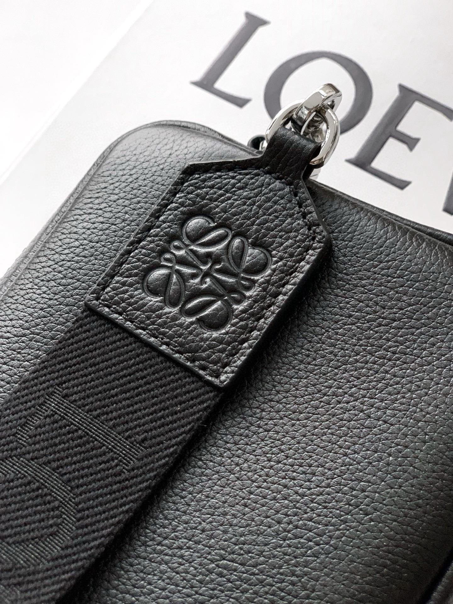 Embossed Loewe leather strap detail with decorative pattern and metal clip
