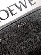 Men's leather bag close-up with embossed LOEWE logo on textured black grainy surface