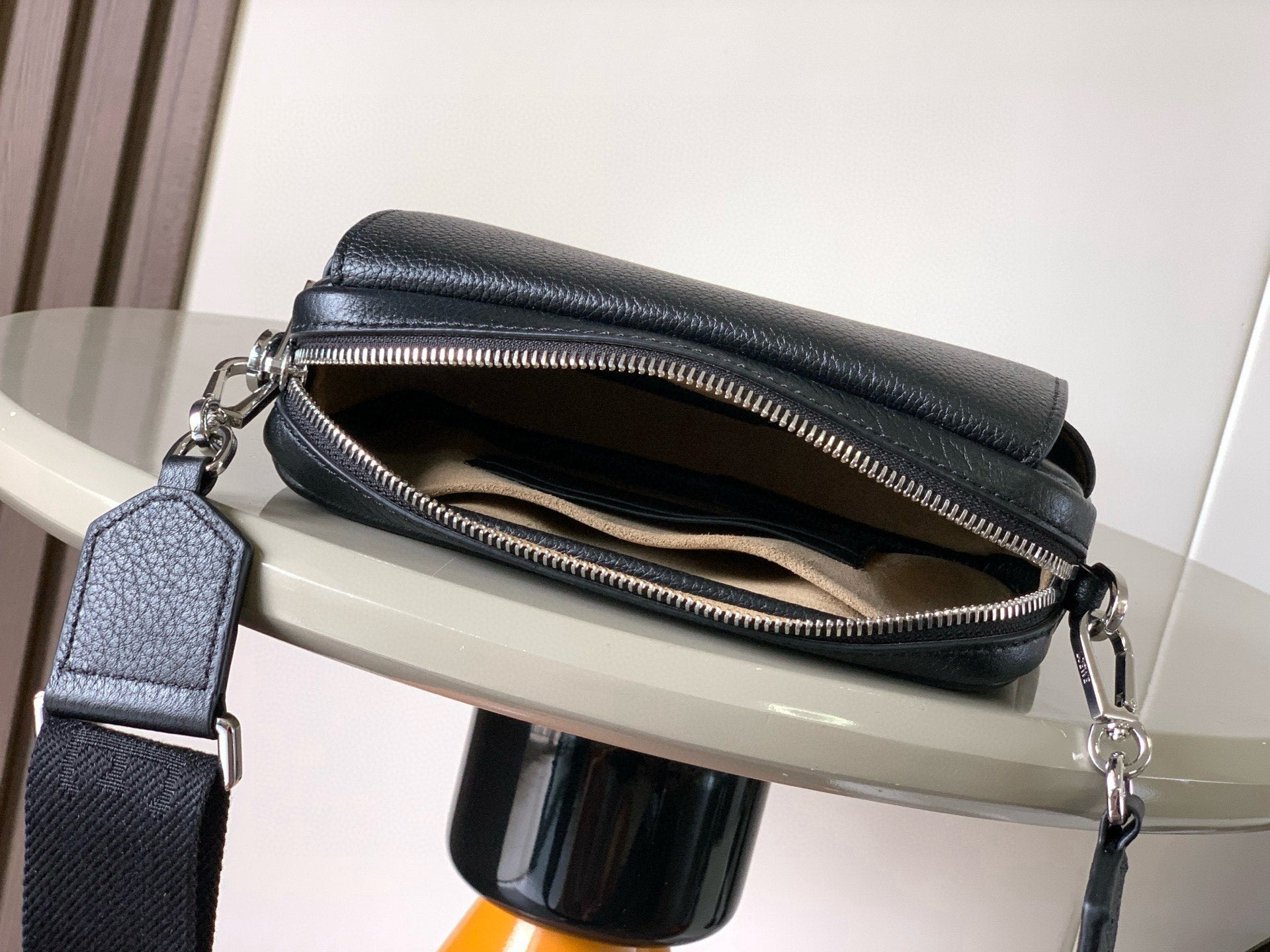 Men's crossbody bag with zipper opening, dark blue leather and visible interior