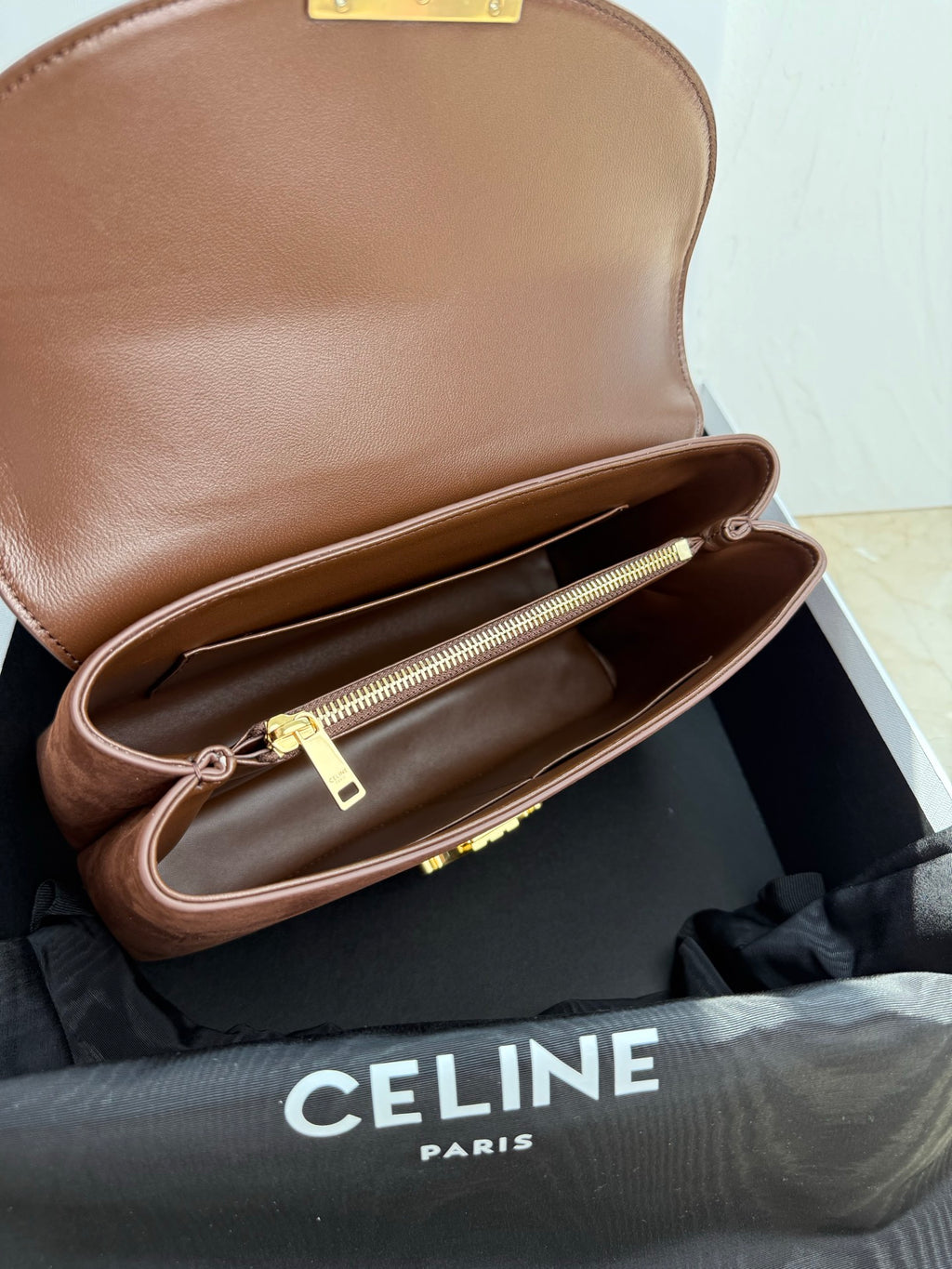 Celine brown leather bag open to show interior lining and gold zipper pocket