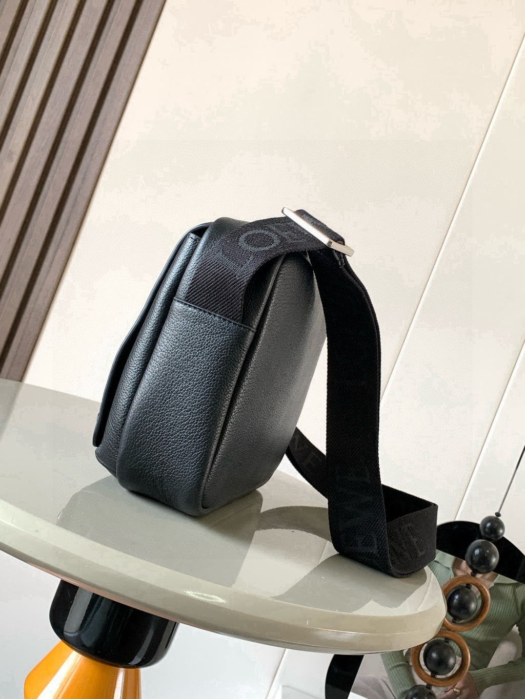 Men's dark leather crossbody bag side view with adjustable strap