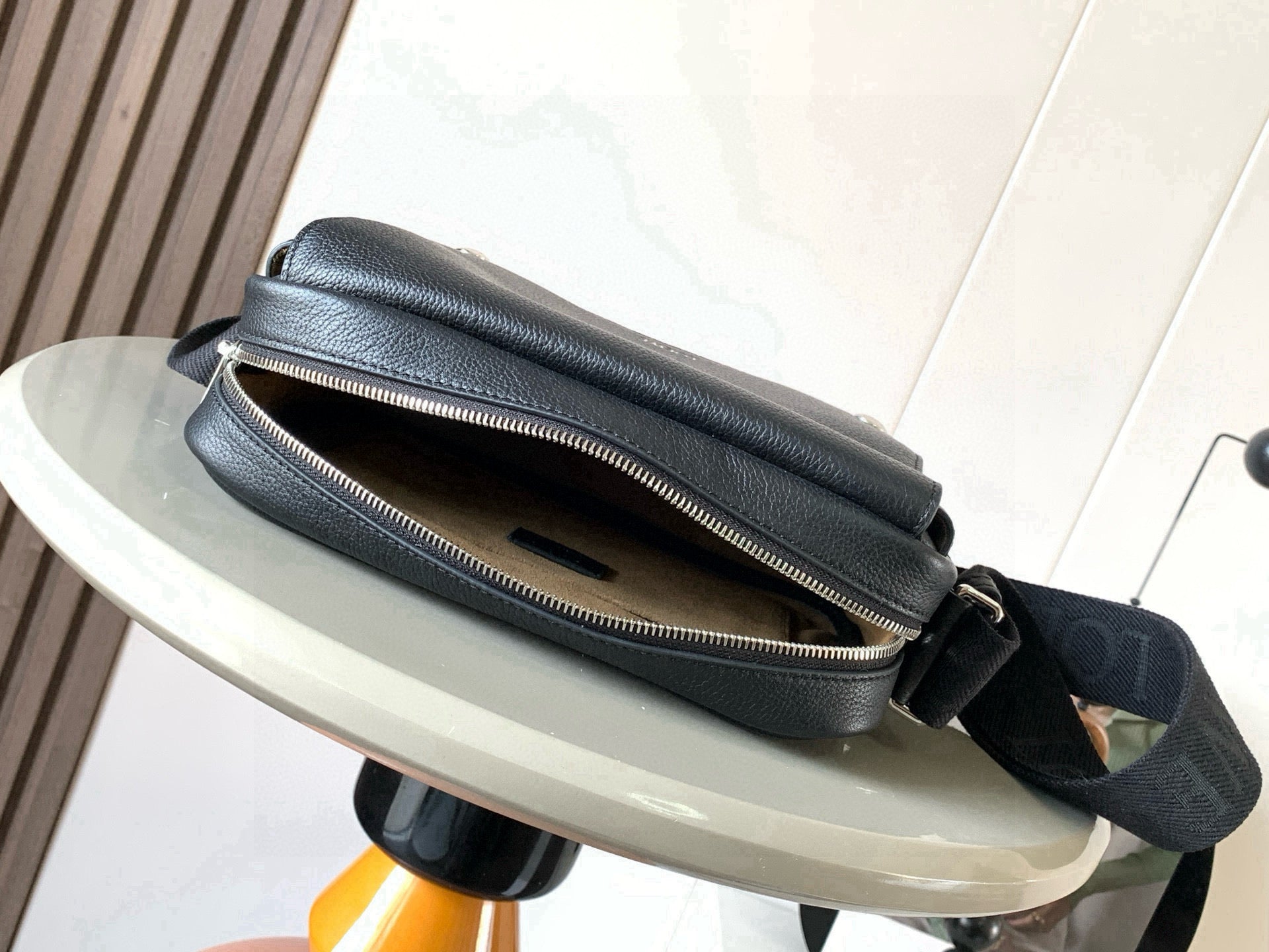 Pebbled leather crossbody bag with top zip opening and adjustable strap