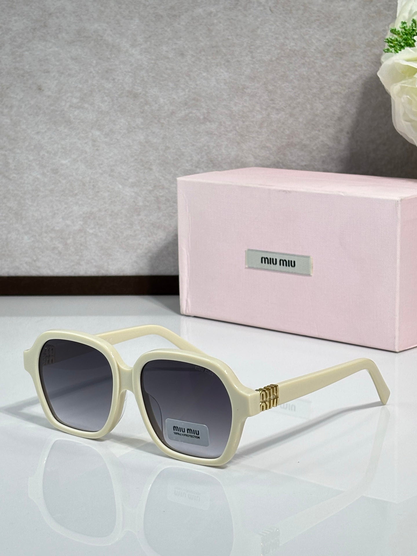 MiuMiu cream square eyeglasses with dark lenses and gold logo temples