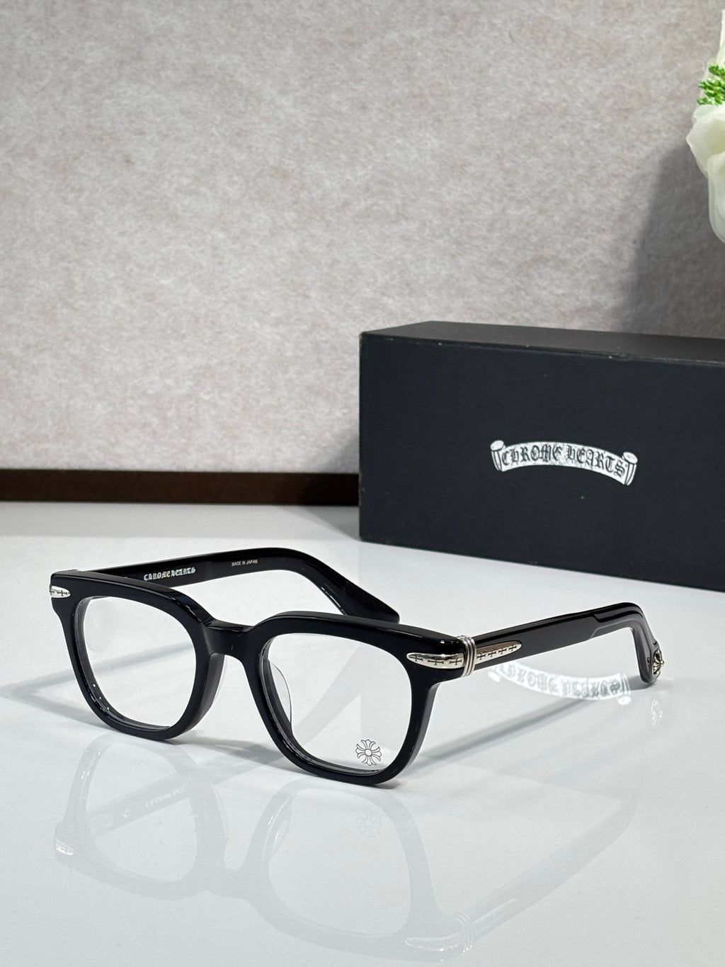 Black full-rim eyeglasses with gold detailing on the temples and rectangular lenses