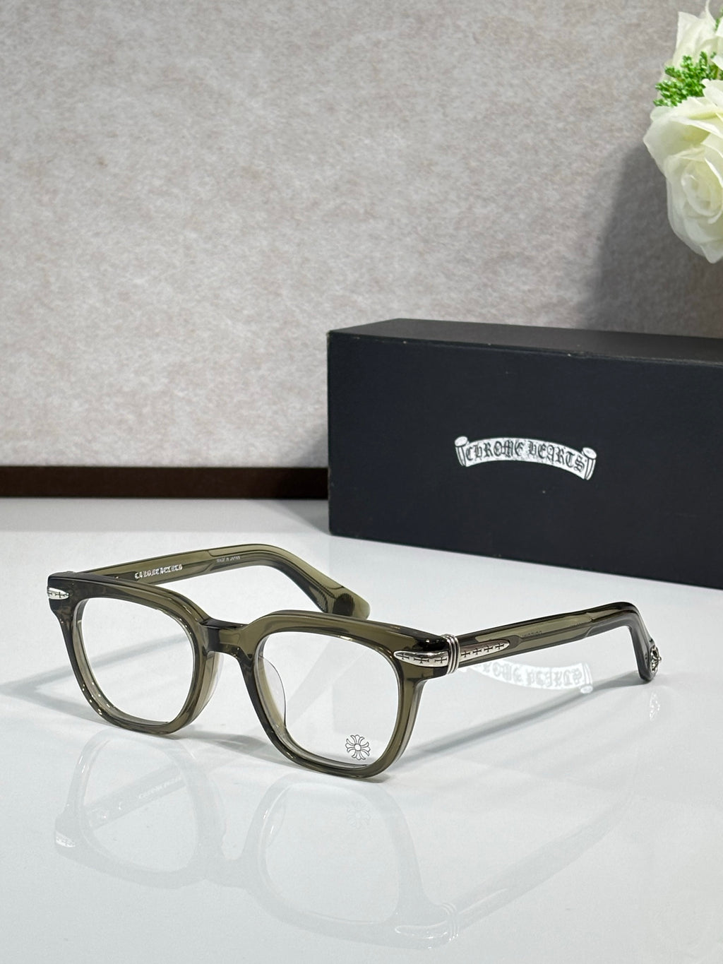 Dark green full-rim eyeglasses with gold-accent temples and rectangular lenses