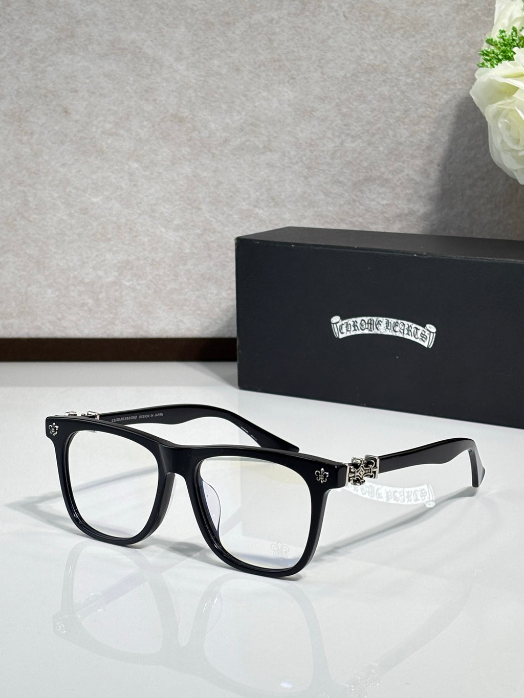 Chrome glasses with black rectangular frames and clear lenses, silver-tone bridge ornament