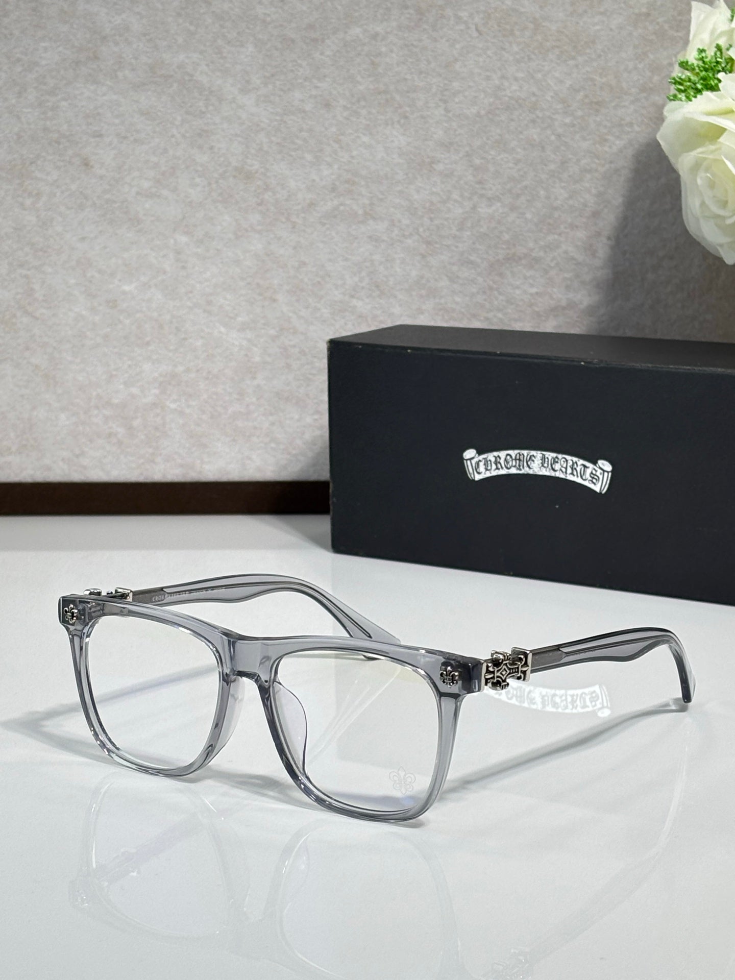 Chrome glasses with translucent gray frames and clear lenses, ornate temple hardware