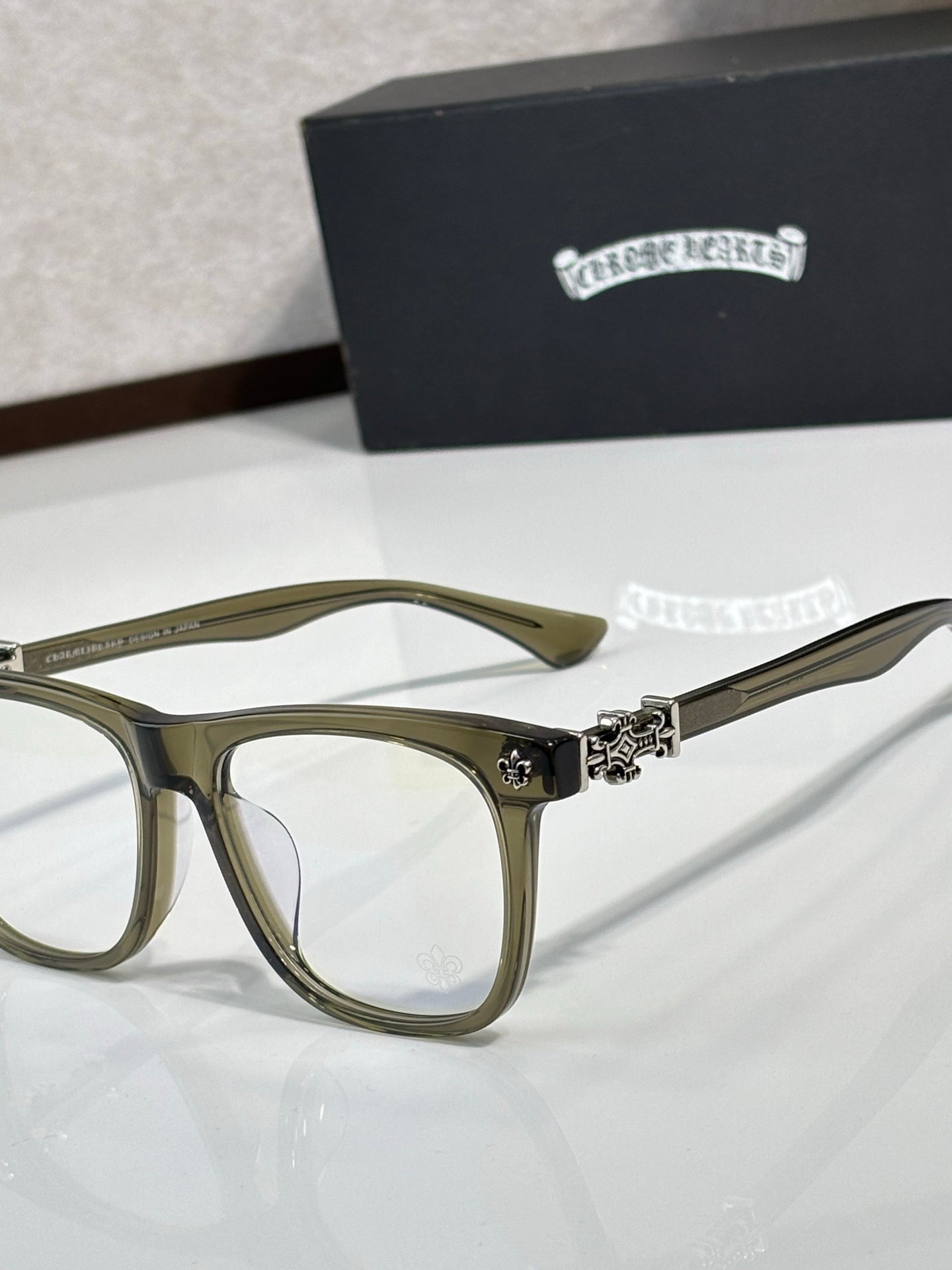 Chrome glasses with olive rectangular frames and clear lenses, decorative hinge at temple