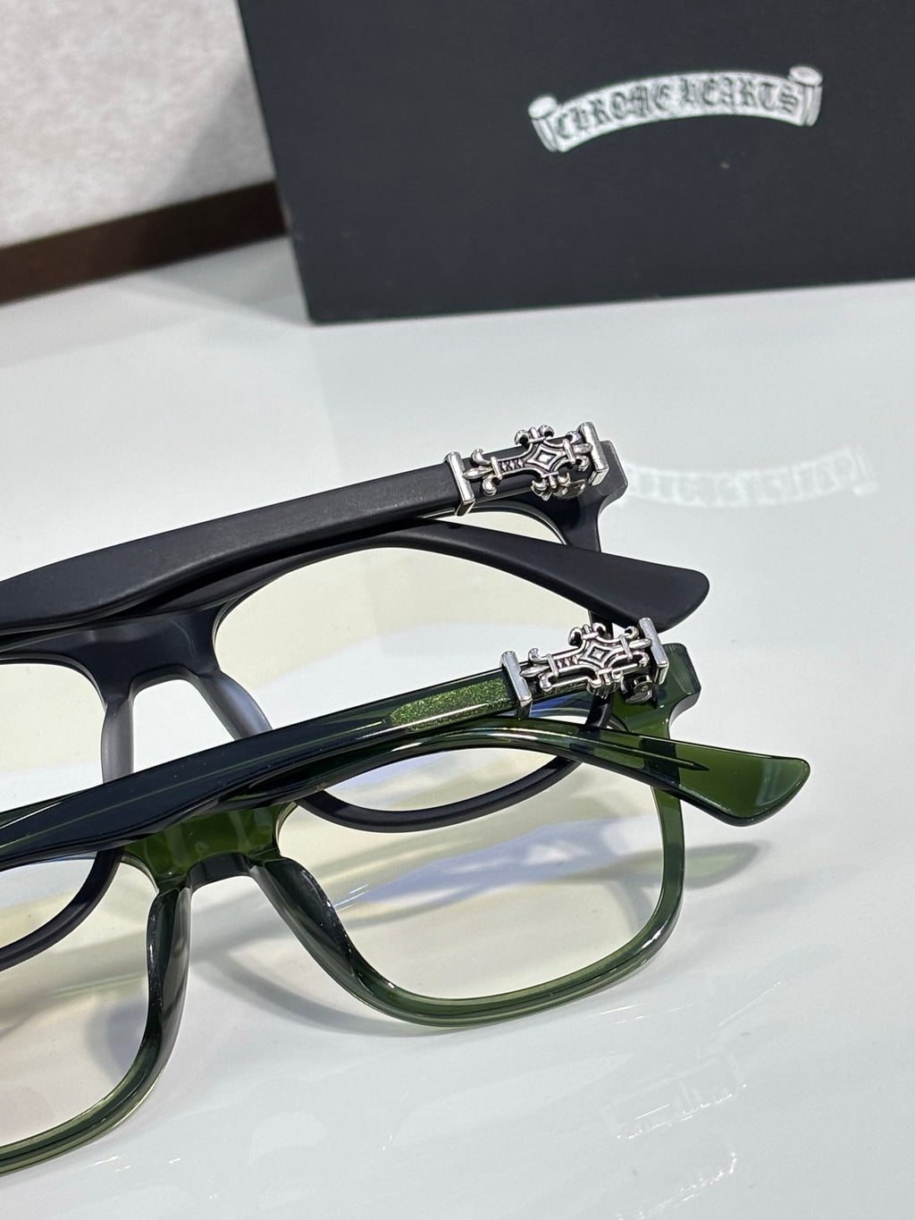 Chrome glasses with dark navy and green rectangular frames, ornate temple hardware
