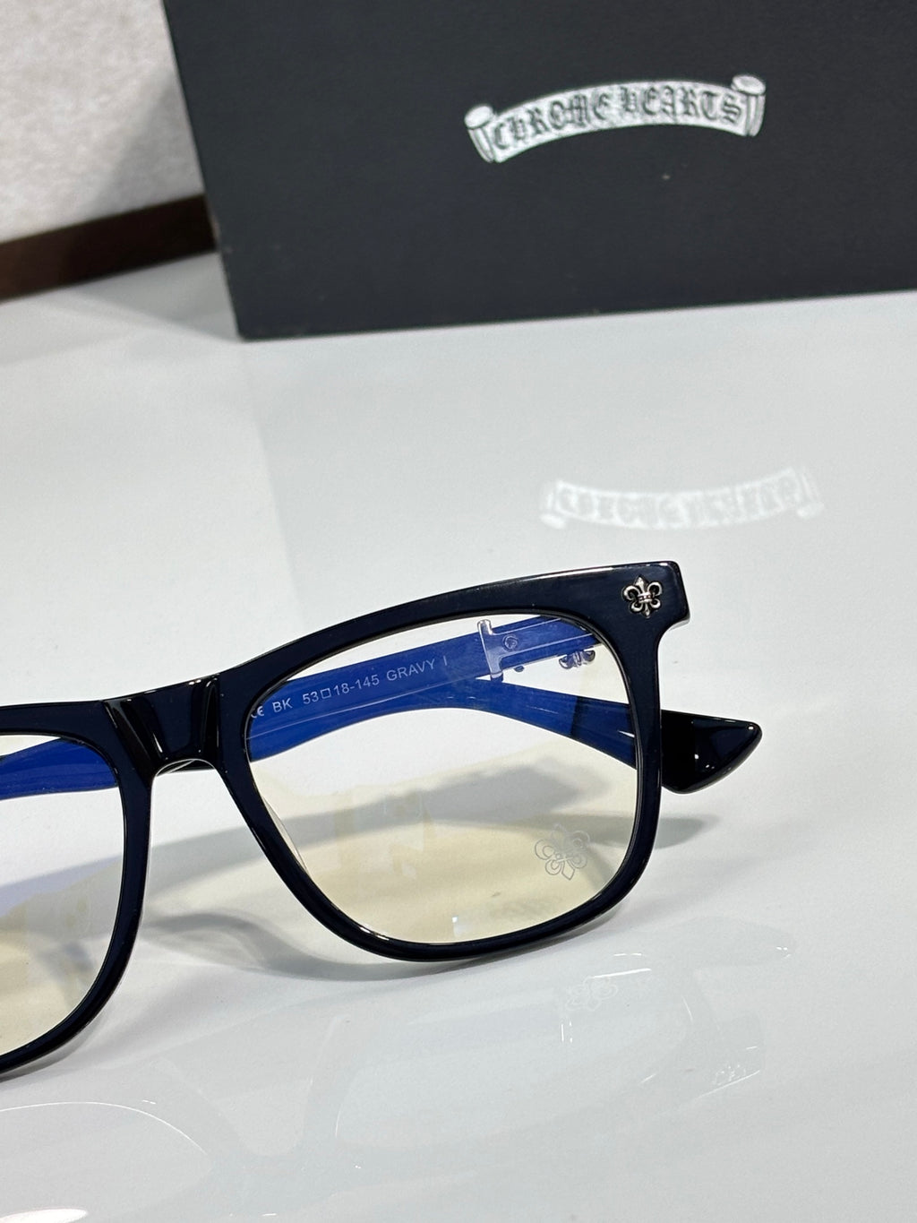 Chrome glasses with dark navy frame and side temple decoration, clear lens view