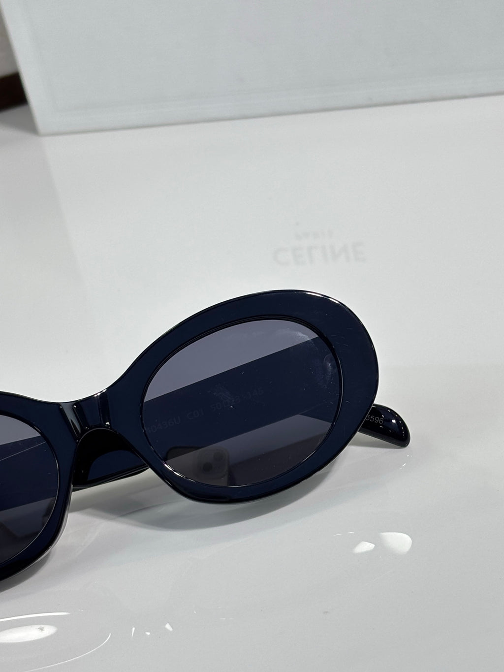 Celine sunglasses close-up with navy oval frames and dark lens