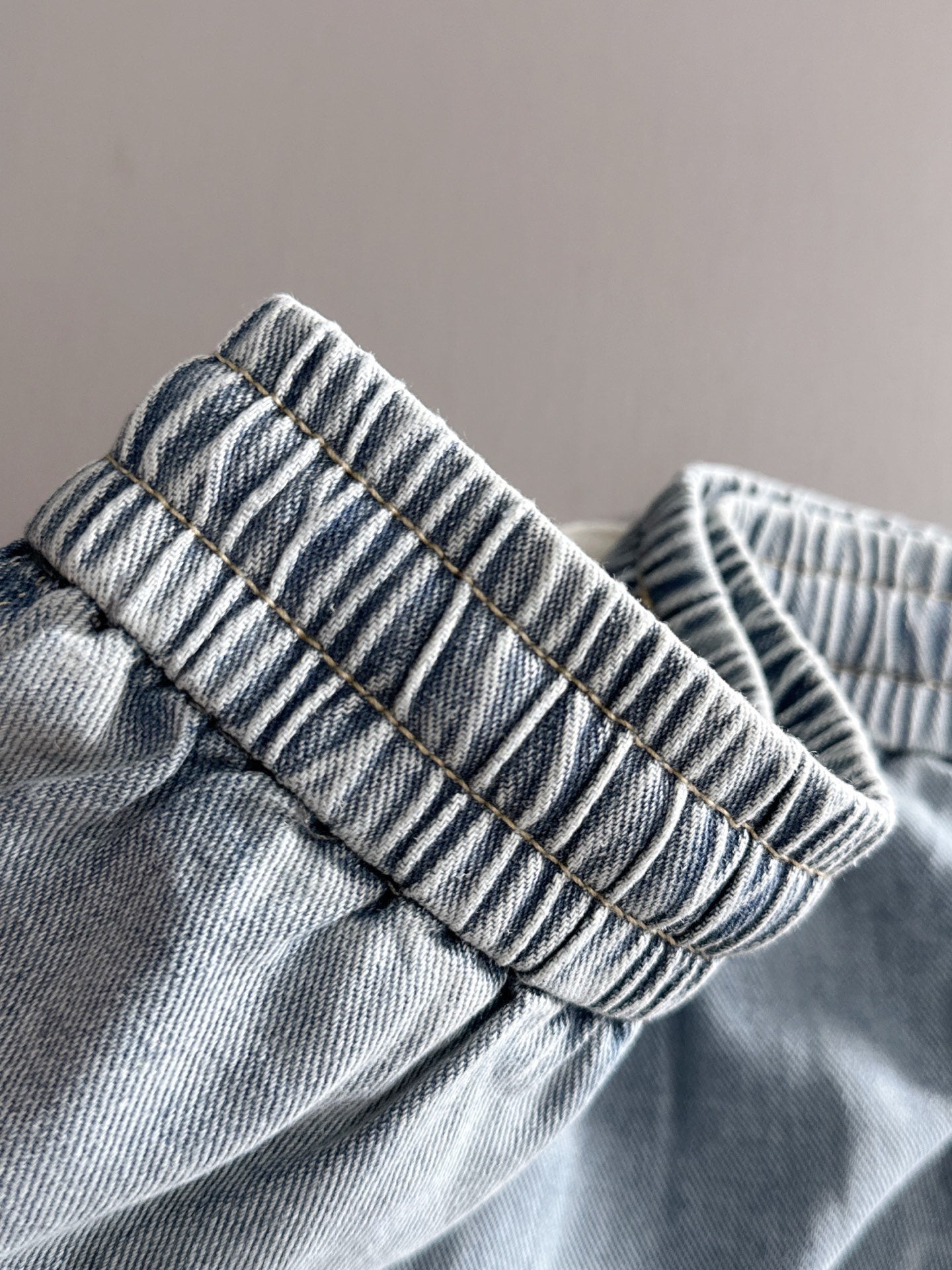 Louis Vuitton light blue denim pants cuff close-up, elastic gathered waistband