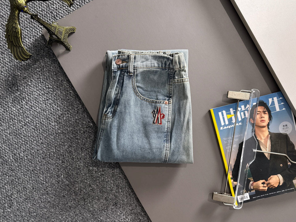 Light blue denim pants with flap pockets and red logo patch on the front