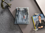 Light blue denim pants with flap pockets and red logo patch on the front