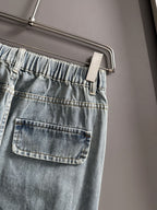 Light blue denim pants close-up of elastic waistband and front flap pocket