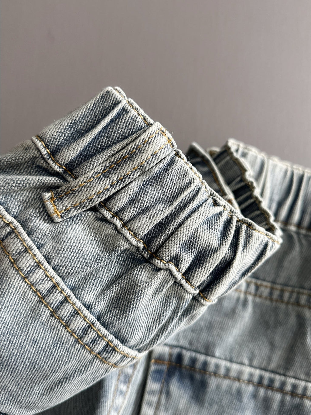 Light blue denim pants close-up of waistband and belt loops