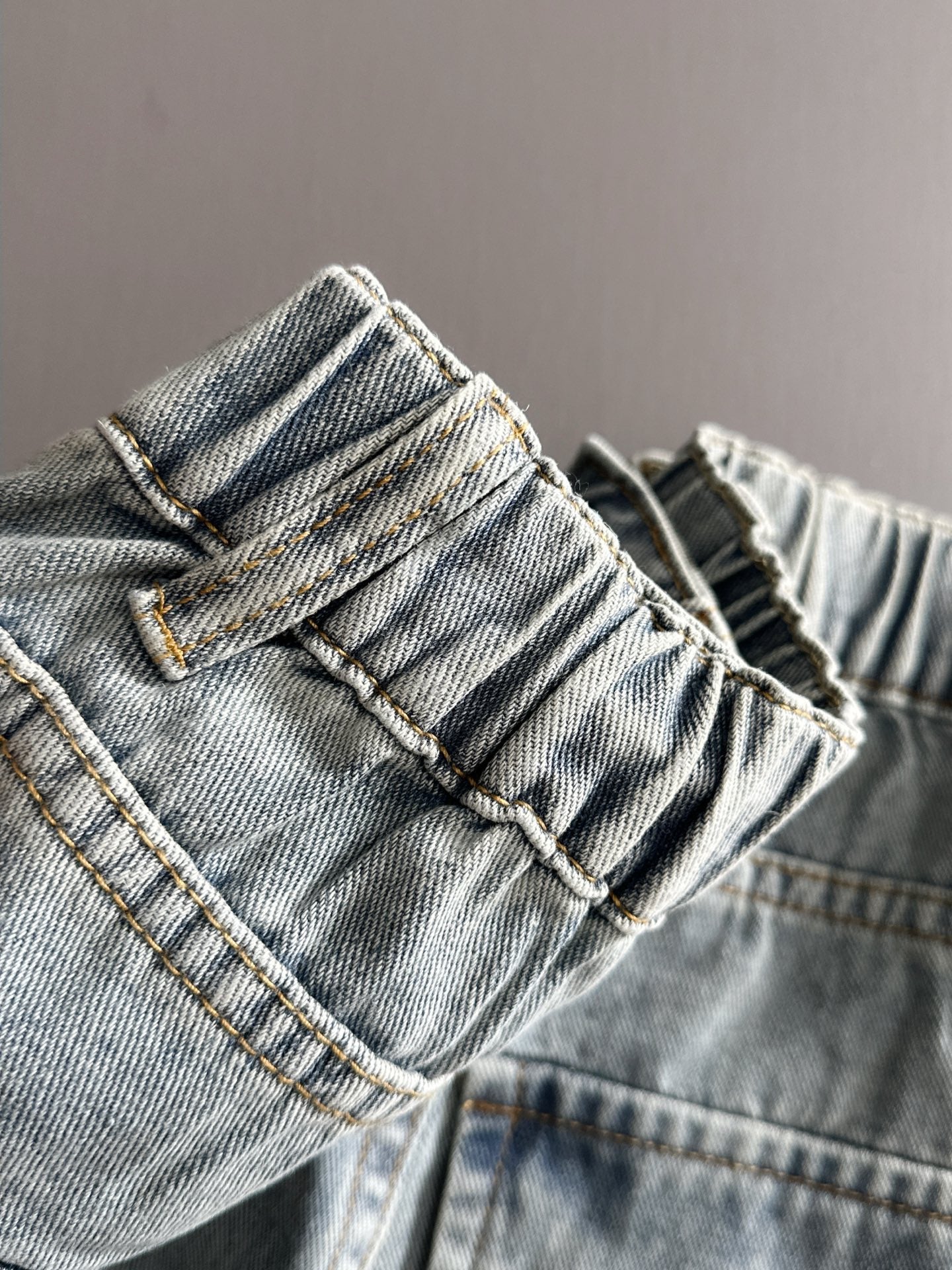 Light blue denim pants close-up of waistband and belt loops