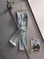 Light blue denim pants hanging on a hanger with cuffed hem and flap pockets