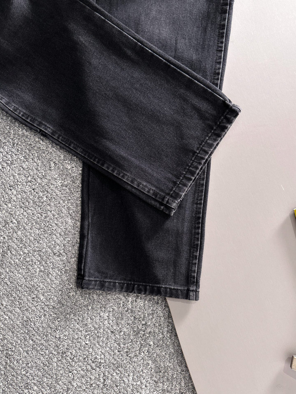 Dior dark denim pants close-up of folded cuff and front pocket detail