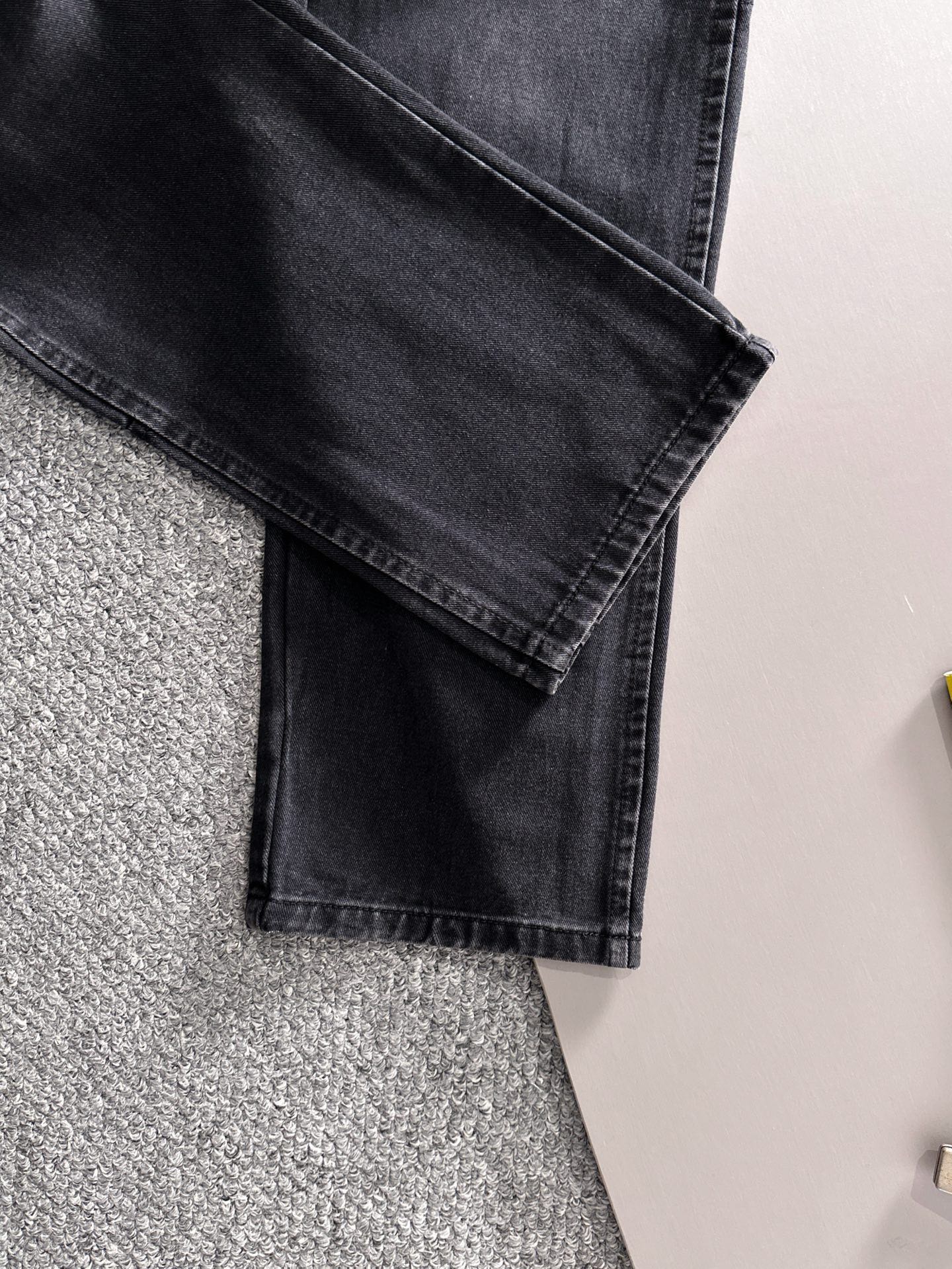 Dior dark denim pants close-up of folded cuff and front pocket detail
