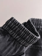 Dior dark denim pants close-up of ribbed elastic waistband and gathered top