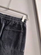 Dior dark denim pants close-up of elastic waistband and front pocket with stitching