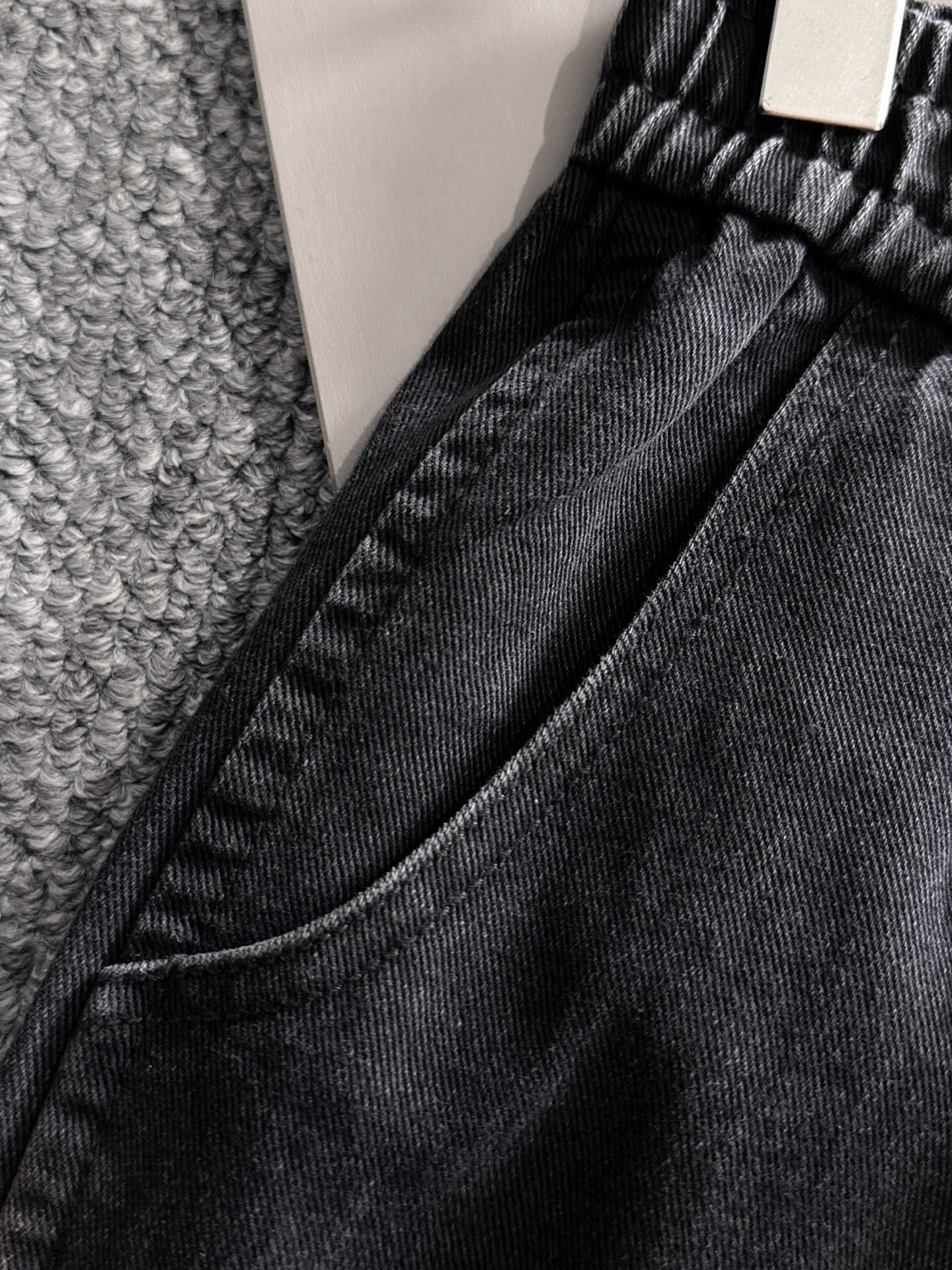Dior dark denim pants close-up of waist seam and stitched drawstring openings