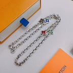 Silver charm necklace with blue flower, red heart, and green flower pendants