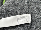 Fuzzy dark gray sweater fabric with white size label and care instructions
