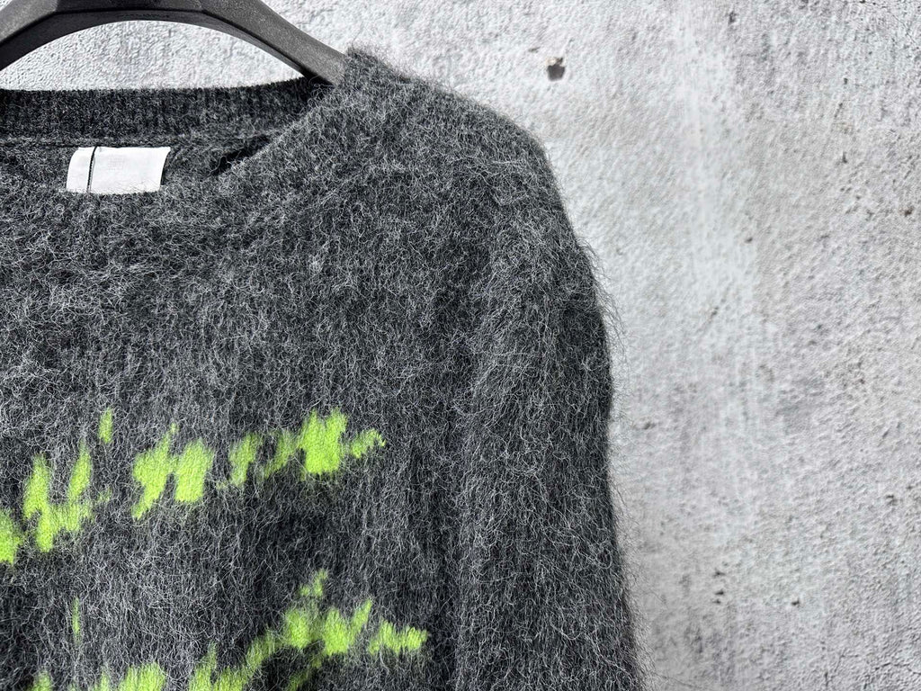 Dark gray fuzzy knit sweater with neon green graphic lettering, close view
