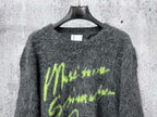 Dark gray fuzzy knit sweater with neon green graphic lettering on chest