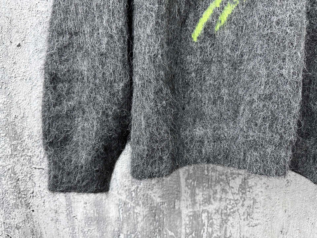 Dark gray fuzzy knit sweater with neon green mark at side and ribbed hem