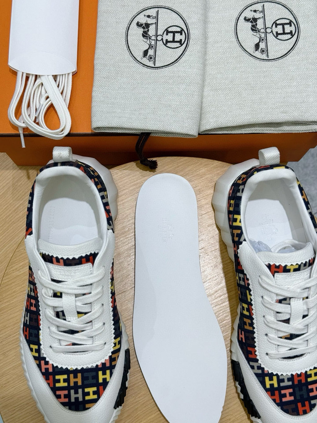 Hermes unisex sneakers with openings visible, white insoles and logo-pattern uppers