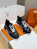 Black low-top sneakers with white laces and repeating H-style logo pattern