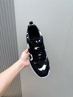 Unisex cow-print sneaker close-up, black laces, patterned side, white rubber sole.