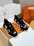 Unisex cow-print sneakers, black upper, lace-up front, white rubber sole.