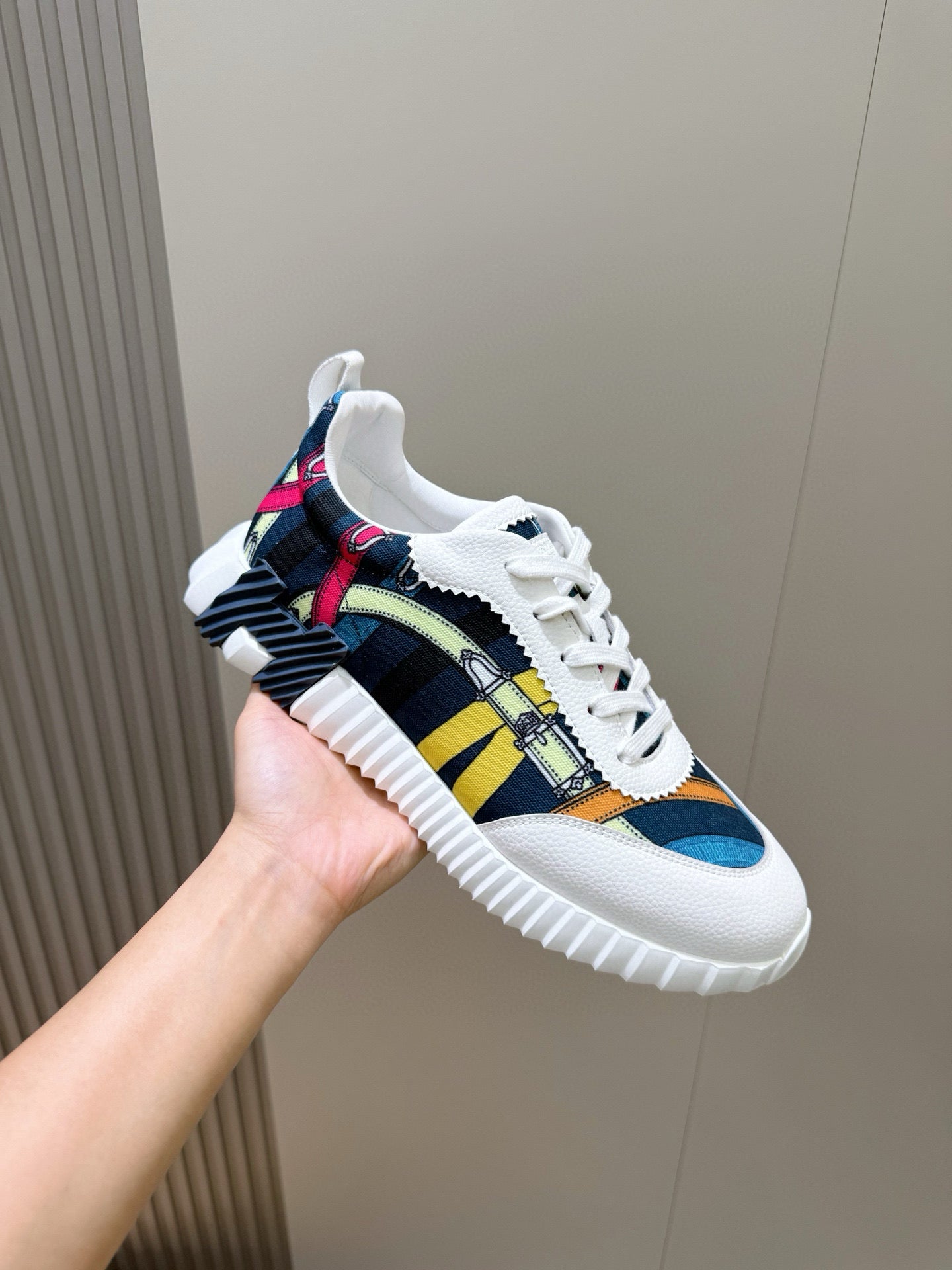 White sneakers with navy, yellow, and multicolor stripe upper and white laces