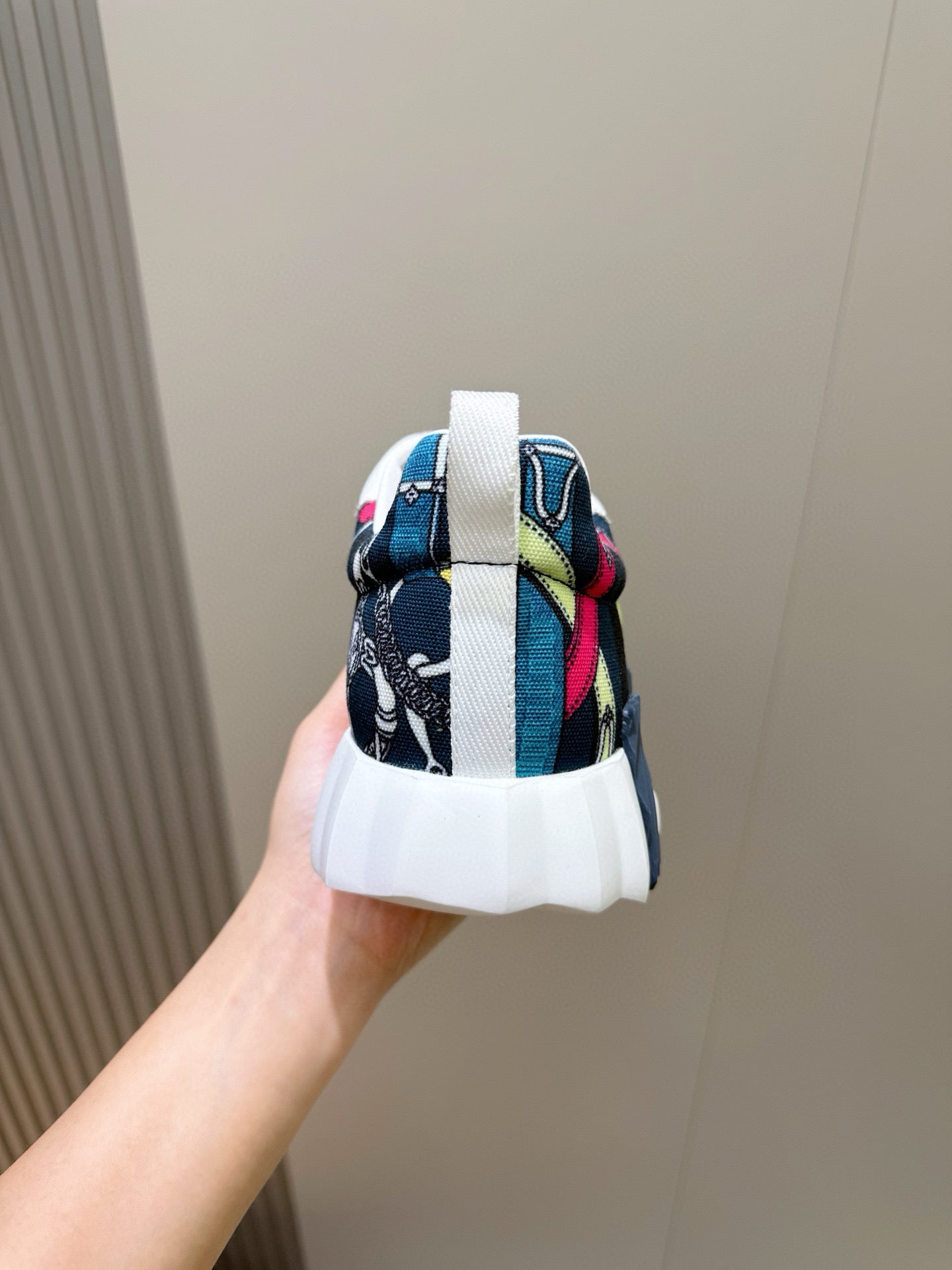 Sneaker heel with blue textile print, colorful accents, and white midsole